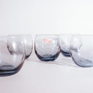 Pu&ograve; includere: Set di sei bicchieri di vetro trasparente con una tinta blu e una texture ondulata. I bicchieri hanno un'etichetta Libbey Glassware sul lato.