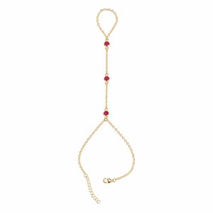 May include: A gold-tone hand chain featuring a delicate link chain design. The piece includes a circular ring loop at the top, connected by a vertical chain segment adorned with three small, round, vibrant pink stones set in gold-tone metal settings.