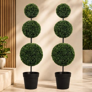 May include: Two artificial topiary trees featuring three stacked spheres of dense green foliage on a central black pole. Each tree is planted in a simple, matte black cylindrical pot, creating a symmetrical and structured appearance for decor.