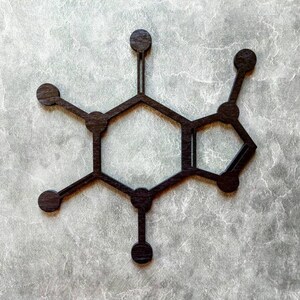 Op de afbeelding: Een zwart houten model van een cafe&iuml;nemolecuul, een chemische verbinding die voorkomt in koffie, thee en andere dranken.