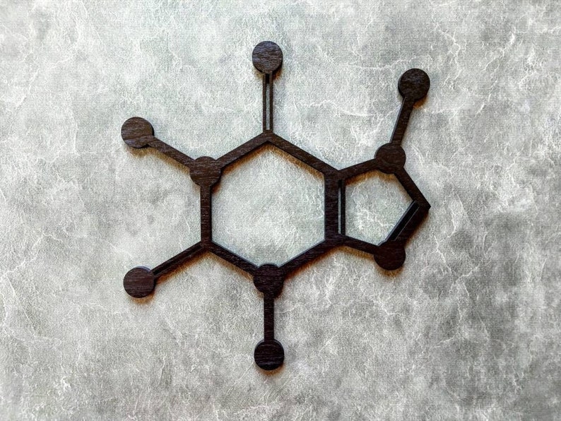 Op de afbeelding: Een zwart houten model van een cafe&iuml;nemolecuul, een chemische verbinding die voorkomt in koffie, thee en andere dranken.