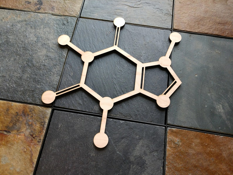 Op de afbeelding: Een houten uitsnijding van een cafe&iuml;nemolecuul, een chemische verbinding die voorkomt in koffie, thee en andere dranken. Het molecuul bestaat uit zes koolstofatomen, tien waterstofatomen en twee stikstofatomen.