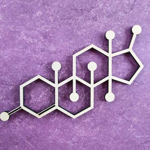 May include: A wooden, white-outlined molecular structure, likely a hormone, against a textured purple background. The design features interconnected hexagons and circles, creating a scientific or educational aesthetic.