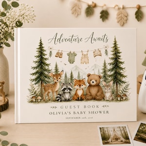 May include: A rectangular guest book with a white cover featuring the text Adventure Awaits, Guest Book, Olivia's Baby Shower, and September 20th, 2026. The illustration shows a forest scene with a deer, raccoon, fox, bear, and rabbit among pine trees.