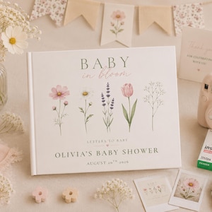 May include: A white hardcover guest book titled BABY in bloom with floral illustrations of cosmos, daisies, lavender, and tulips. The cover includes the text LETTERS TO BABY, OLIVIA'S BABY SHOWER, and AUGUST 20TH 2026 in a dark green font.