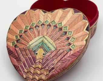 May include: Heart-shaped decorative box with a lid, featuring a detailed mosaic design in shades of pink, orange, green, and purple. The interior is lined with red fabric. The box is open, revealing the interior.