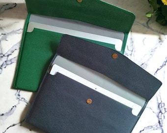 May include: Two open folders, one green and one dark blue, with a silver divider inside each. The folders have a textured fabric exterior and gold metal clasps.