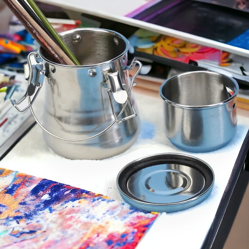 May include: A set of three stainless steel paint brush cleaning containers. The largest container has a lid and a handle. The smallest container is a lid for the medium-sized container.