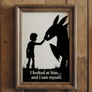Puede incluir: Impresión artística enmarcada con una silueta negra de un niño tocando el hocico de un dragón. El texto "I looked at him... and I saw myself" está debajo. El marco es de color marrón claro.