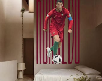May include: A red and green soccer jersey with the number 7 on the front. The jersey is worn by a soccer player with the name "RONALDO" printed in large letters on the wall behind him.