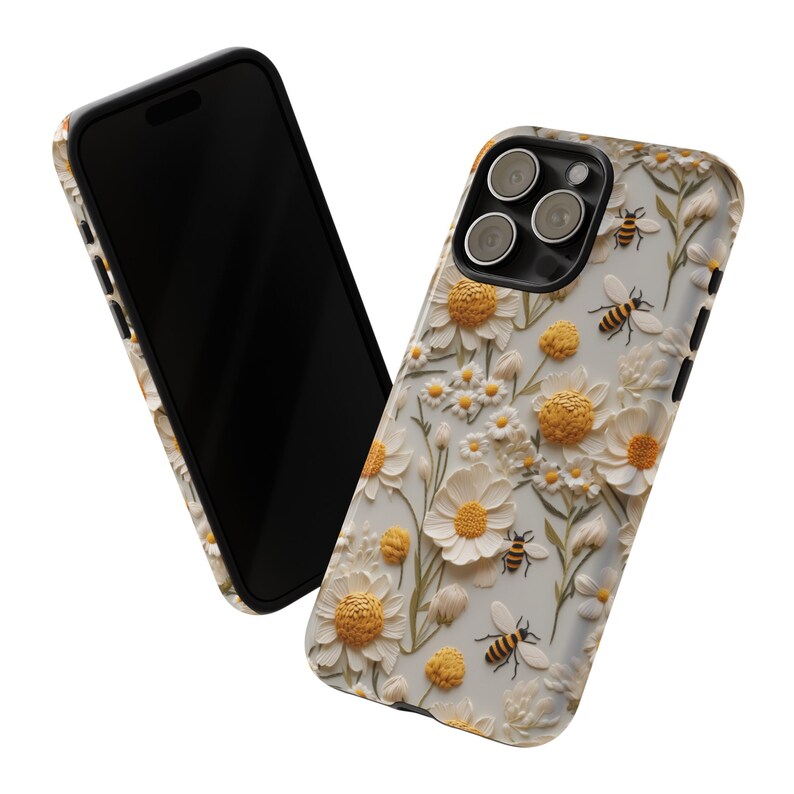 Pu&ograve; includere: Una custodia per telefono trasparente con un design di margherite bianche e api. La custodia ha un bordo rialzato attorno alle lenti della fotocamera.
