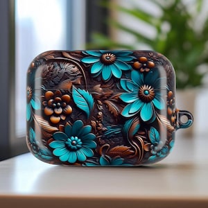 May include: A decorative case for wireless earbuds, featuring a floral design. The case is primarily brown with teal and orange flowers and leaves. The case has a smooth, glossy finish and a small loop for attaching to a keychain or bag.
