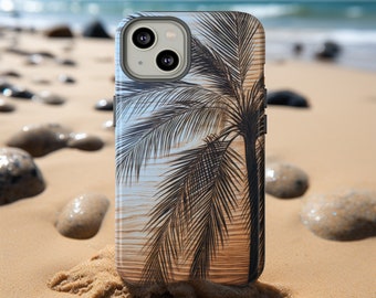 May include: A phone case featuring a black palm tree design against a backdrop of a beach scene with a blue sky and ocean. The case is resting on a sandy beach with rocks in the background.