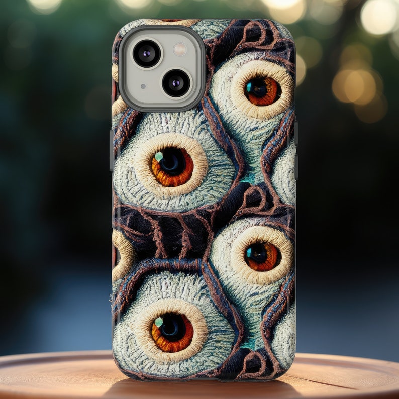 May include: A phone case with a design of multiple eyes with brown irises and white scleras. The eyes are set against a dark brown background with a textured pattern.