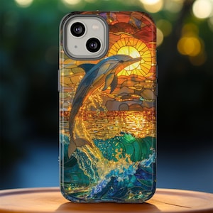 May include: A stained glass phone case with a dolphin jumping out of the water, a sunset, and a blue and green ocean.