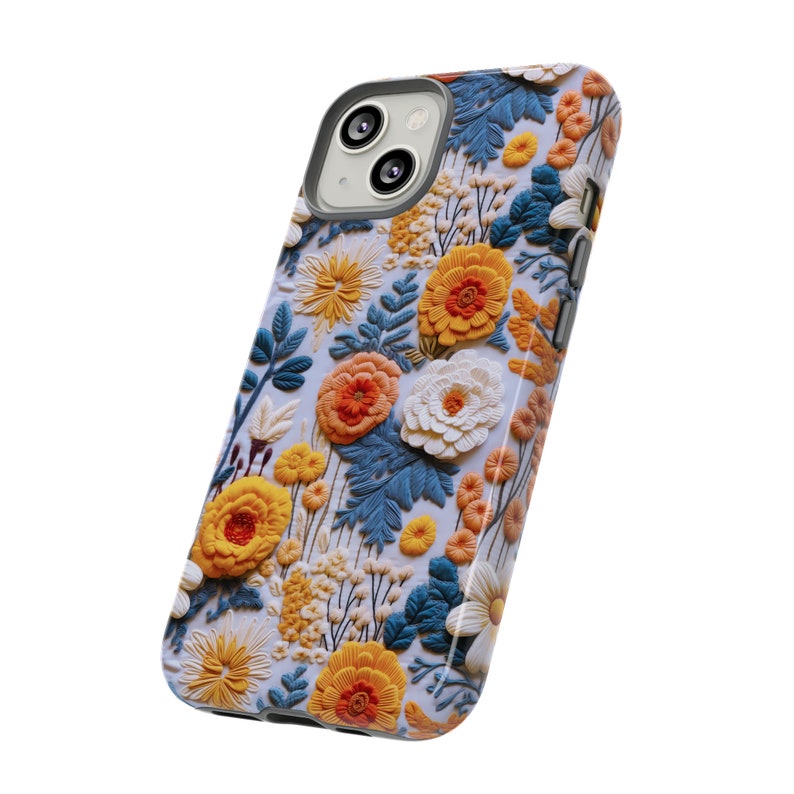 Pode incluir: Uma capa de telefone com um design floral com flores amarelas, laranja e azuis sobre um fundo branco.