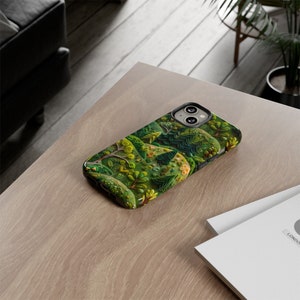 May include: A green, black and white phone case with a forest scene design. The case has a raised design and is made of durable material.