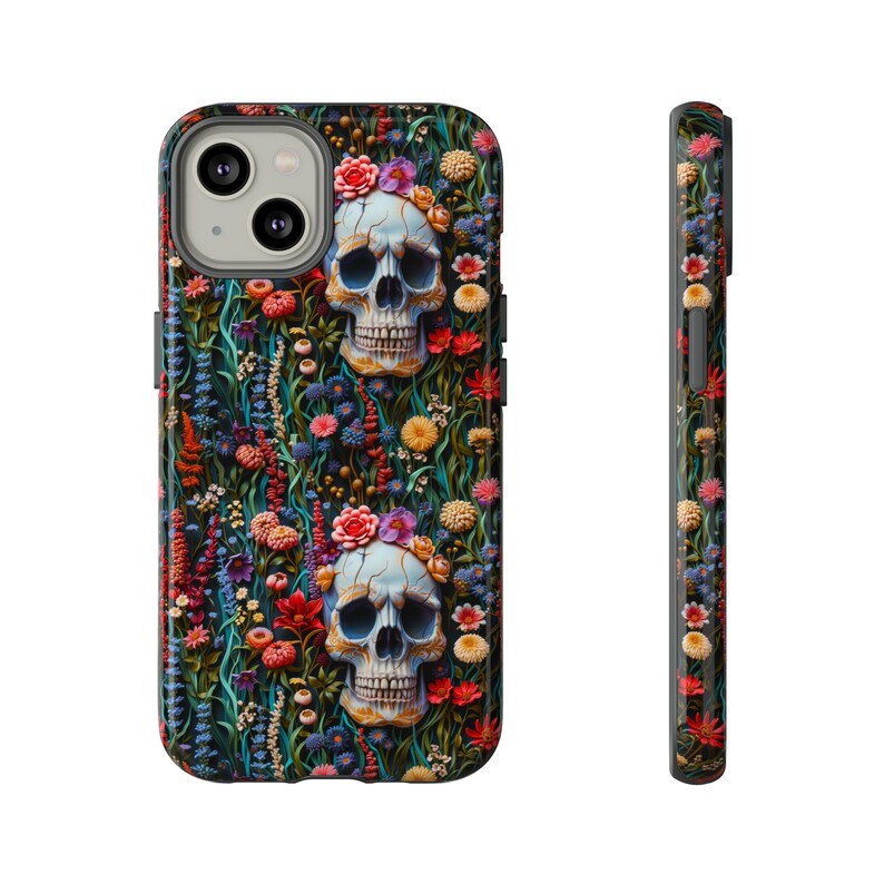 Peut inclure: Une coque de t&eacute;l&eacute;phone noire avec un motif floral color&eacute; et deux cr&acirc;nes blancs avec des couronnes de fleurs.