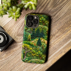 May include: A green, brown and white phone case with a whimsical forest scene. The case features a variety of trees, flowers and other foliage.