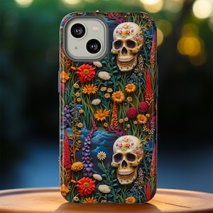 Peut inclure: Une coque de t&eacute;l&eacute;phone noire avec un motif floral color&eacute; et deux cr&acirc;nes de sucre. Les cr&acirc;nes sont d&eacute;cor&eacute;s de fleurs et ont un fond blanc.