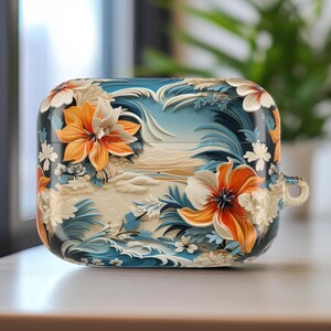 May include: A decorative case for wireless earbuds featuring a floral design. The case has a base color of dark blue with a relief pattern of orange and white flowers, blue waves, and a light beige landscape.