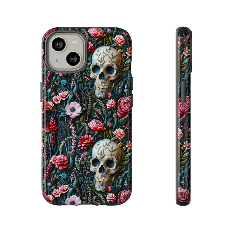 Peut inclure: Une coque de t&eacute;l&eacute;phone noire avec un motif floral compos&eacute; de fleurs roses, rouges et blanches. Deux cr&acirc;nes blancs aux yeux noirs sont &eacute;galement repr&eacute;sent&eacute;s sur la coque.