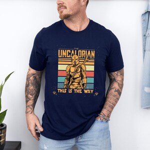 Retro Mandalorian-inspired design with "The Uncalorian" and "This Is The Way" text on a t-shirt.