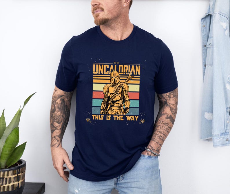 Retro Mandalorian-inspired design with "The Uncalorian" and "This Is The Way" text on a t-shirt.