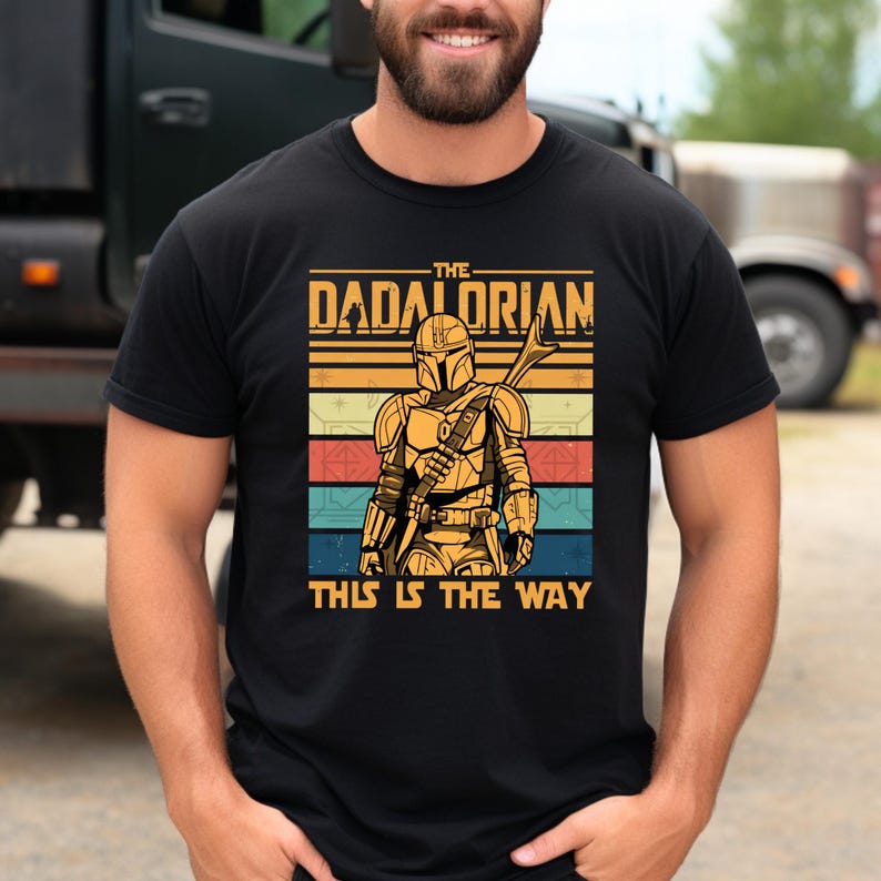 Dadalorian" text with Mandalorian figure in retro colors, featuring "This Is The Way" on a t-shirt.