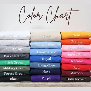 A color chart displaying various colored shirts, including white, ash, sport gray, light blue, dark gray, navy, red, maroon, and purple.