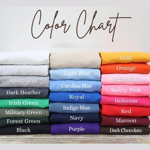 A color chart displaying various colored shirts, including white, ash, sport gray, light blue, dark gray, navy, red, maroon, and purple.
