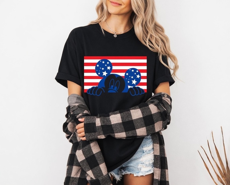 Patriotic design with a character silhouette against American flag stripes and stars on a t-shirt.