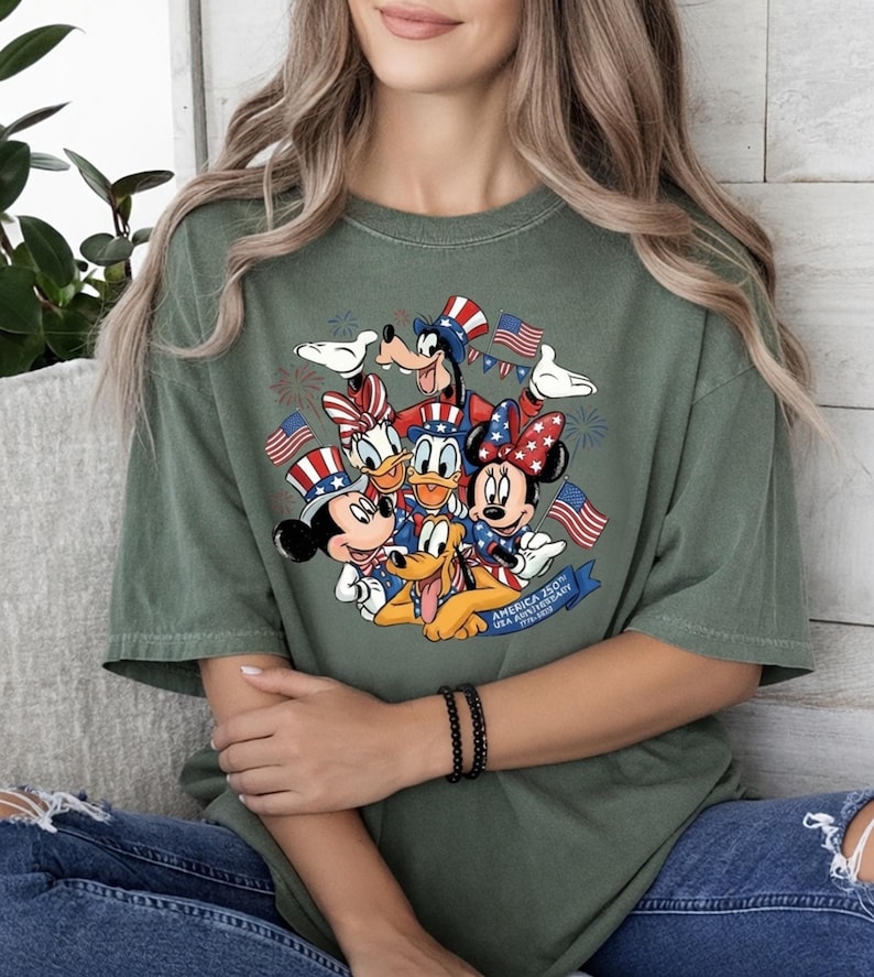 Mickey and Friends in patriotic hats with American flags and fireworks, celebrating USA 250th on a t-shirt.