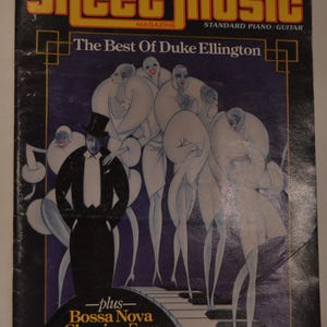 May include: A magazine cover featuring a colourful illustration of a man in a tuxedo and a top hat with a group of women in white dresses. The magazine is titled "Sheet Music" and the cover text reads "The Best of Duke Ellington" and "Bossa Nova Classics From Antonio Carlos Jobim".