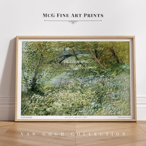 May include: A painting by Vincent van Gogh titled "The Bridge at Arles" depicting a bridge over a river with lush green trees and foliage. The painting is framed in a light wood frame.