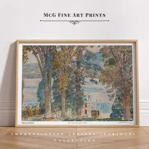 Puede incluir: Impresión artística enmarcada de una pintura de paisaje impresionista. La obra presenta árboles, una masa de agua y un edificio. La impresión está etiquetada como "MCG Fine Art Prints" e incluye el nombre del artista, Childe Hassam.
