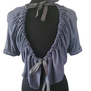 May include: A blue, short-sleeved, cropped top with a gathered neckline and a tie at the back.