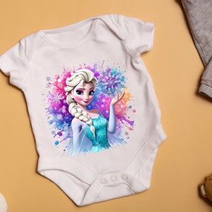 May include: White baby onesie with a colorful watercolor design featuring a cartoon image of Elsa from Frozen. Elsa is wearing a blue and white dress and holding a snowflake.