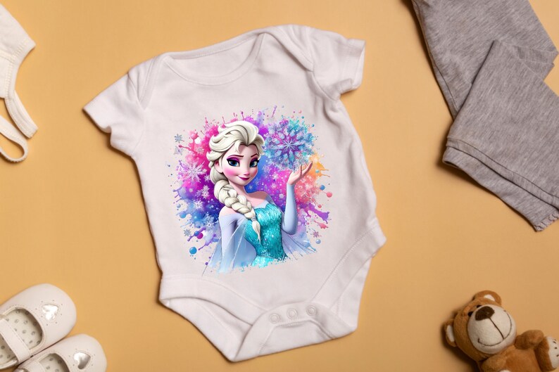 May include: White baby onesie with a colorful watercolor design featuring a cartoon image of Elsa from Frozen. Elsa is wearing a blue and white dress and holding a snowflake.