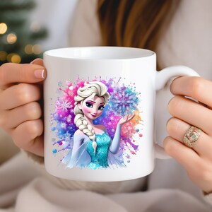 May include: White ceramic mug with a colorful watercolor design featuring Elsa from Frozen. Elsa is holding a snowflake and is surrounded by blue, pink, and purple watercolor splatters.