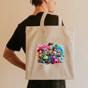 Op de afbeelding: Een beige tote bag met een kleurrijke print van de Toy Story-personages, waaronder Woody, Buzz Lightyear en Jessie. De personages staan voor een kleurrijke achtergrond met verfspatten.