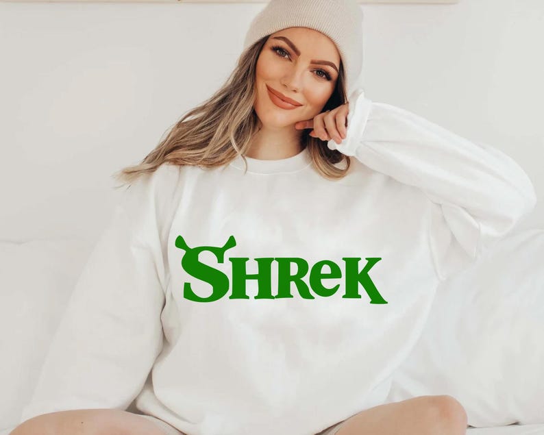 May include: White sweatshirt with a green "Shrek" graphic on the front.