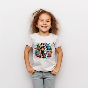 Op de afbeelding: Een wit T-shirt met een kleurrijke grafische print van personages uit de Toy Story-franchise. De personages zijn in een cirkelvormige opstelling geplaatst met een spattende kleurrijke verf erachter.