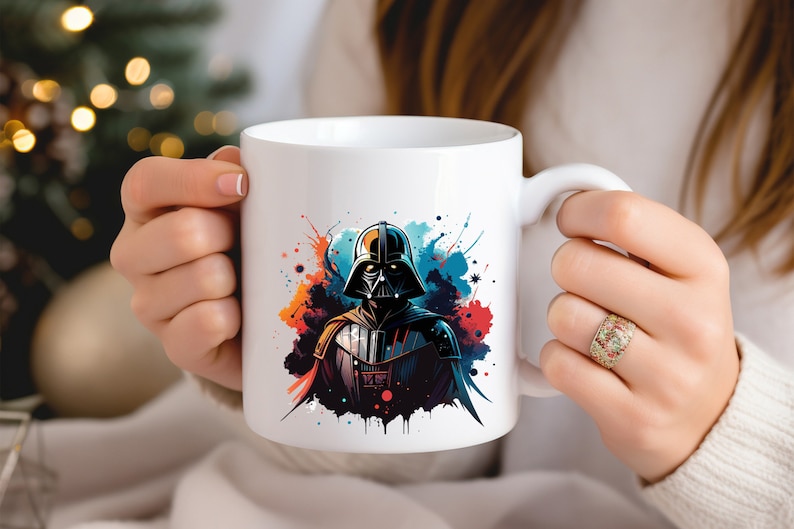 Op de afbeelding: Witte keramische mok met een gestileerde illustratie van Darth Vader, versierd met kleurrijke verfspatten. Het ontwerp bevat tinten zwart, blauw, rood en oranje. De mok heeft een standaard handvat.