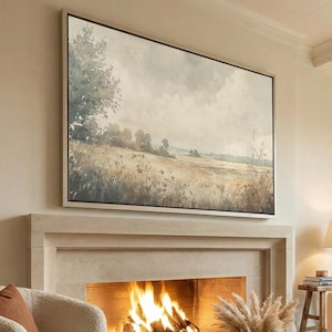 Peut inclure: Une grande peinture de paysage rectangulaire dans un cadre fin est suspendue au-dessus d'une cheminée. L'œuvre représente un champ aux tons sourds avec des herbes hautes et des arbres lointains sous un ciel nuageux, dans des tons beige, brun et vert.