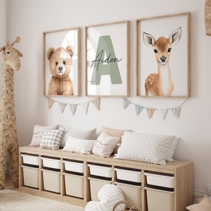 May include: A nursery room with a wooden storage bench, three framed prints with a teddy bear, a deer, and the letter A with the name Aiden, and a woven giraffe toy.
