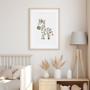 Puede incluir: Una impresi&oacute;n enmarcada de una ilustraci&oacute;n de acuarela de una cebra con rayas blancas y negras. La cebra est&aacute; de pie sobre un fondo blanco. El marco es de madera clara.