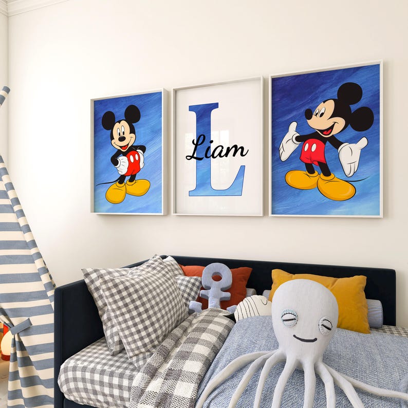 Op de afbeelding: Drie ingelijste prints voor een kinderkamer. De middelste print heeft een blauwe letter L met de naam Liam in het zwart. De prints aan beide kanten hebben Mickey Mouse op een blauwe achtergrond.