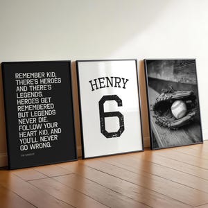 Op de afbeelding: Drie ingelijste prints tegen een muur. De linkerprint is zwart met witte tekst. De middelste print is wit met "HENRY" en het nummer "6" in zwart. De rechterprint is een zwart-wit foto van een honkbal en handschoen.