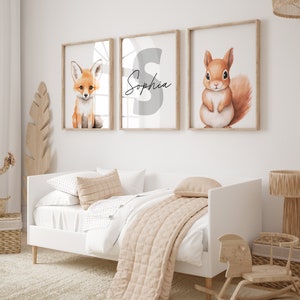 May include: Three framed prints with a white background. The left print features a cartoon fox, the middle print features the letter "S" and the name "Sophia" written in cursive, and the right print features a cartoon squirrel.
